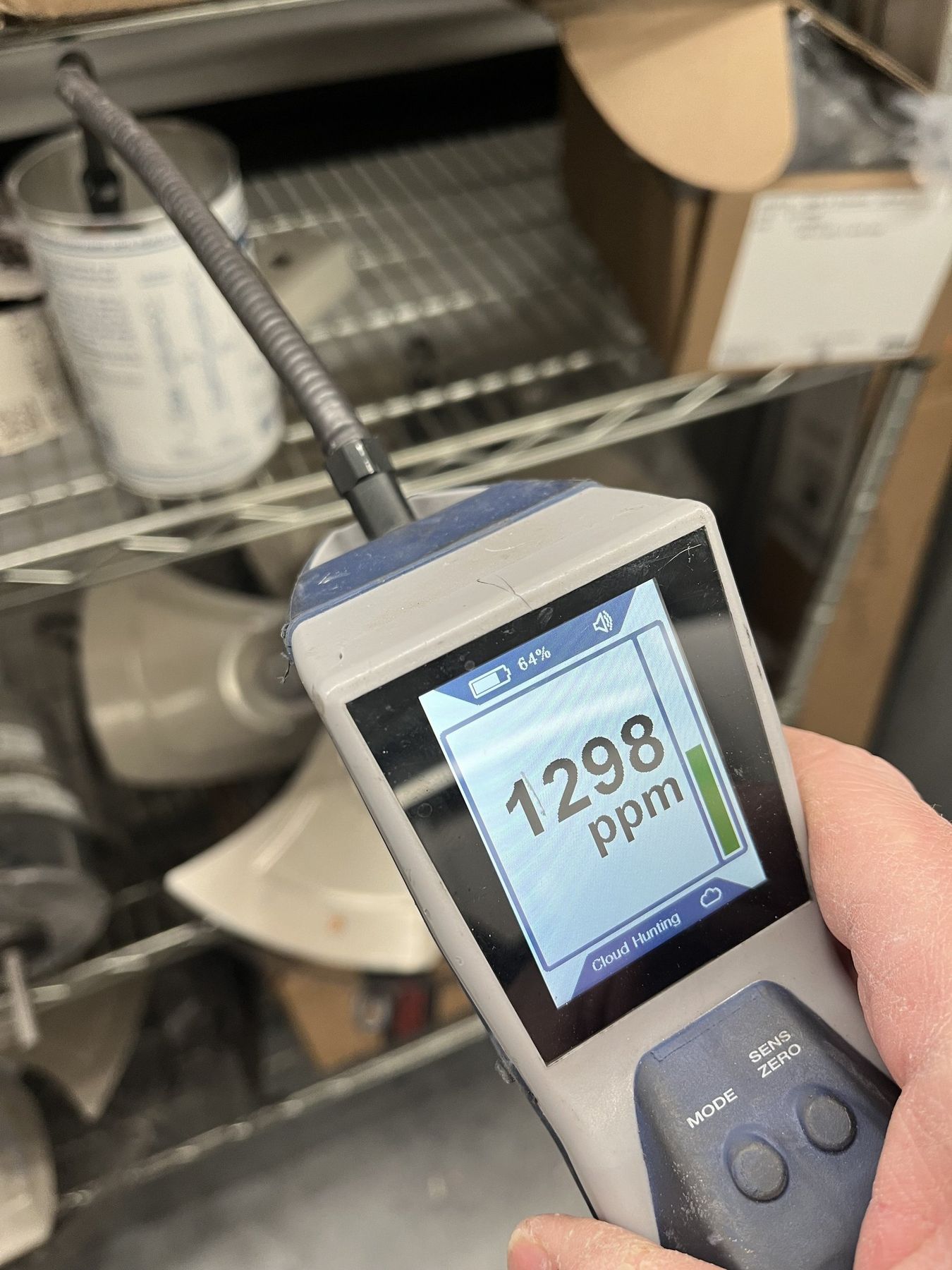 SRV technician holding an electronic refrigerant leak detector showing a reading during a service call in Idaho Falls